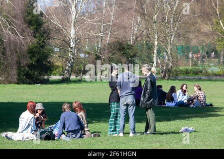 Londra, Regno Unito, 29 marzo 2021: A Brockwell Park, a sud di Londra, la gente ha approfittato del tempo soleggiato il primo giorno di allentamento della chiusura in Inghilterra. Alcune persone esercitate e altre picnicked in piccoli gruppi. Per i genitori di bambini piccoli la possibilità di un contatto sociale è essenziale per la loro salute mentale e per lo sviluppo dei loro figli. Anna Watson/Alamy Live News Foto Stock