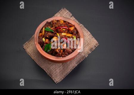 Arrosto di manzo o pothu ulartheyadu, piatto speciale kerala arrangiato in terracotta in modo tradizionale guarnito con pezzi di cocco. Foto Stock