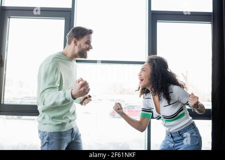 i partner commerciali sono entusiasti di guardare l'un l'altro mentre mostrano il trionfo gesto in ufficio Foto Stock