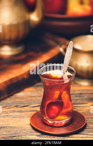 Bicchiere di gustoso tè turco su sfondo di legno Foto Stock