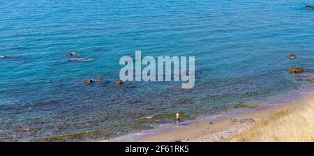 Lone figura camminare sulla spiaggia di Carvajal, Provincia di Malaga, Costa del Sol, Spagna. Foto Stock