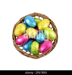 Uova di Pasqua nel cestino . Uova di cioccolato avvolte in lamina colorata. Foto Stock