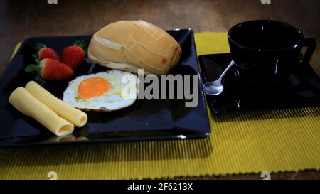 salvador, bahia / brasile - 18 maggio 2020: prima colazione a base di pane, uova fritte, fragole e formaggio. *** Local Caption *** Foto Stock