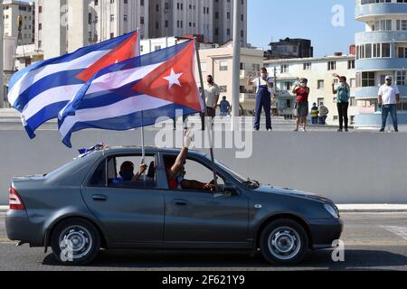 L'Avana, Cuba. 28 Marzo 2021. La gente partecipa a una carovana a l'Avana, Cuba, il 28 marzo 2021. Un'auto, una moto e una carovana in bicicletta la domenica si sono fatti strada attraverso il viale marittimo dell'Avana, chiedendo l'abolizione dell'embargo degli Stati Uniti di sei decenni contro l'isola, noto come 'blocco' tra la gente del posto. Credit: Zhu Wanjun/Xinhua/Alamy Live News Foto Stock