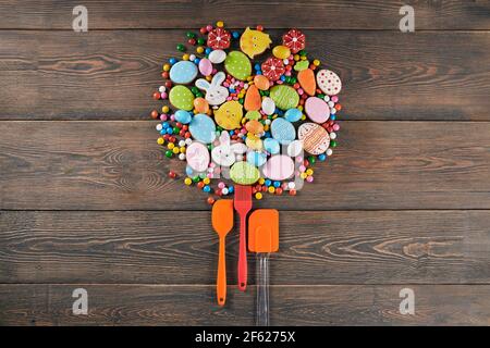 Vista dall'alto della splendida composizione a forma di cerchio fatta di pan di zenzero, caramelle e utensili culinari. Concetto di preparazione di biscotti fatti in casa per il tempo di Pasqua. Foto Stock