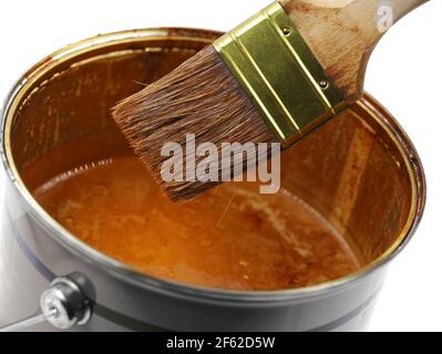 secchio di vernice con smalto di legno marrone e pennello usato, primo piano Foto Stock