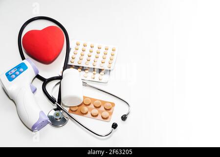 Un cuore con uno stetoscopio si trova su uno sfondo chiaro. Cuore sano. Foto Stock