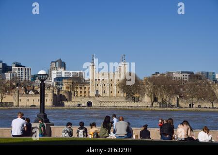 Londra, Regno Unito. 29 marzo 2021. La gente gode del sole nel Potters Fields Park con vista sulla Torre di Londra. Le persone affollano gli spazi aperti in una giornata calda, mentre le regole di blocco sono rilassate in Inghilterra. Credit: SOPA Images Limited/Alamy Live News Foto Stock