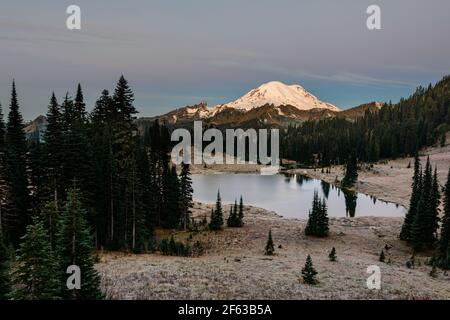 Alba caduta gelida al lago Tipsoo nel Monte Rainier National Parco con la montagna visibile all'orizzonte e il lago ad alta quota in primo piano Foto Stock