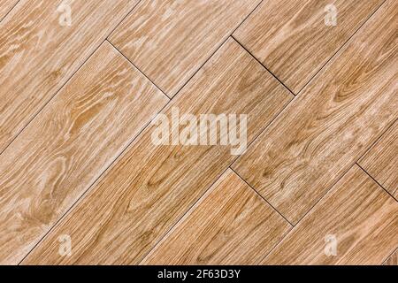 Struttura di tavole arancioni e marroni per pavimento o tavolo, sfondo diagonale in legno. Foto Stock