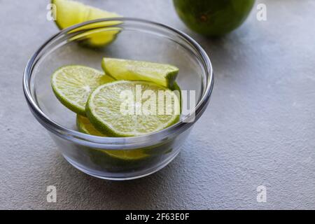 Primo piano delle fette di lime verde nel recipiente di vetro Foto Stock