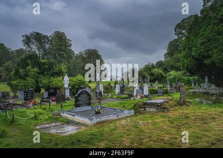 Killarney, Irlanda, agosto 2019 Cimitero circondato da alberi verdi, accanto all'abbazia di Muckross del XV secolo, Killarney National Park Foto Stock