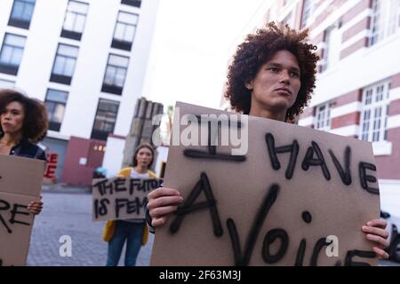 Il protetore maschile di razza mista ha tenuto una protesta casalinga segno Foto Stock