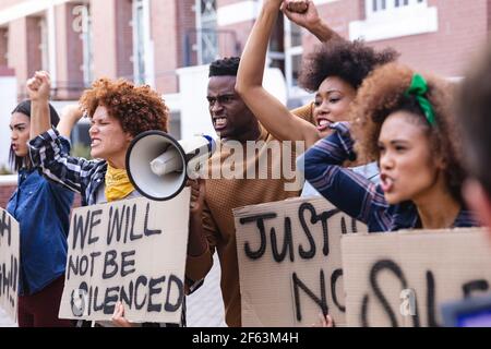 Diversi manifestanti maschili e femminili si sono manifestati a marzo con segnali di protesta, urlando e usando il megafono Foto Stock