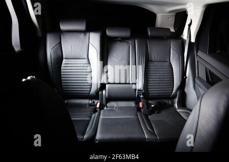 Interni di lusso scuro per auto nuove. Sedili posteriori per passeggeri in auto moderna. Sedili posteriori e cinture di sicurezza in pelle Foto Stock
