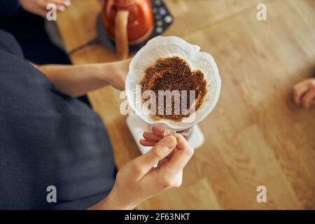 Delizioso caffè in polvere appena macinato nel filtro del caffè. Vista dall'alto Foto Stock