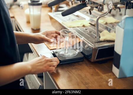 Barista professionista che prepara il caffè utilizzando la macchina per il caffè e il bollitore antigoccia chemex. Metodi alternativi per preparare il caffè. Concetto di caffetteria Foto Stock