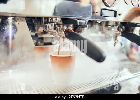 Close-up di versare il caffè espresso dalla macchina per il caffè. Professional per l'infusione di caffè Foto Stock