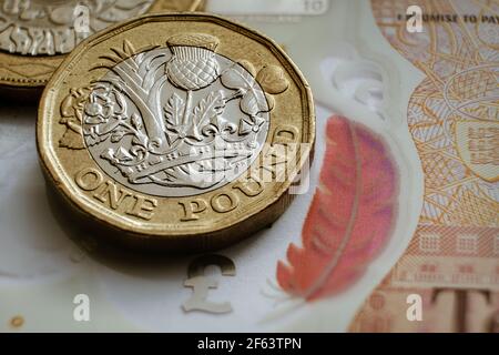 Monete inglesi da una libbra poste su una banconota da 10 libbre. Concetto. Messa a fuoco selettiva. Macro. Foto Stock