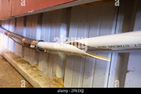 Burnett, Texas USA 23 febbraio 2021: Una rara tempesta invernale estesa con temperature di congelamento ha causato la rottura di tubi idraulici in tutto il Texas centrale, compreso questo tubo in PVC da 2 pollici all'interno di un garage. ©Bob Daemmrich Foto Stock