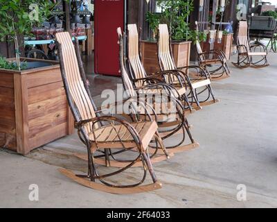 Sedie a dondolo di legno per la vendita allineati in una fila in esposizione ad un negozio di campagna in Pike Road Alabama, Stati Uniti. Foto Stock