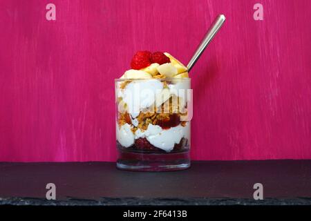 Una parfait allo yogurt con muesli e lamponi freschi Foto Stock