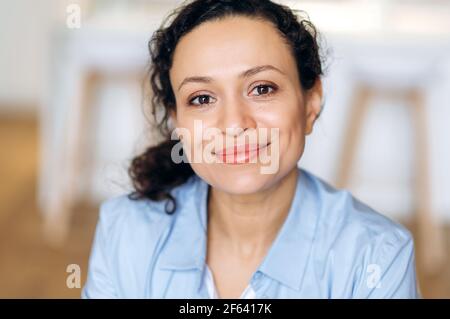 Ritratto formale femminile. Primo piano ritratto di gioiosa donna di razza mista elegante, donna di affari o assistente, vestita in camicia formale e occhiali, guardando la macchina fotografica, sorridente amichevole Foto Stock