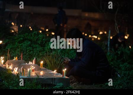 Srinagar, India. 29 marzo 2021. Un uomo musulmano sciita accende candele sulla tomba del suo parente durante l'occasione Shab-e-Barat a Srinagar.Shab-e-barat è un festival osservato dai musulmani tra la 14 e la 15 notte dell'8 ° mese islamico Shia'aban, che pregano tutta la notte con la convinzione che Dio deciderà la fortuna di tutti in questa notte. Inoltre, i dodici musulmani sciiti commemorano il compleanno del 12° Imam Muhammad al-Mahdi in questa data. (Foto di Idrees Abbas/SOPA Images/Sipa USA) Credit: Sipa USA/Alamy Live News Foto Stock