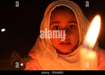 Srinagar, India. 29 marzo 2021. I musulmani sciiti del Kashmiri illuminano le candele sulle tombe durante la festa di Shab-e-Barat (Mid-Shaa'ban), che segna la metà del mese islamico dello Shaban e due settimane prima dell'inizio del mese santo di digiuno del Ramadan, E su cui dodici sciiti commemorano la nascita di Imam Mahdi (l'Imam finale della setta), a Zadibal, una città vecchia di Srinagar. (Foto di Adil Abass/Pacific Press) Credit: Pacific Press Media Production Corp./Alamy Live News Foto Stock