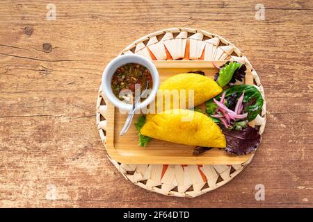 Un'empanada colombiana ripiena di maiale tirato e servita con Pico de Gallo Foto Stock