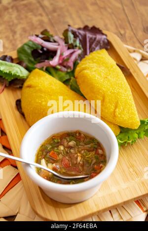 Un'empanada colombiana ripiena di maiale tirato e servita con Ritratto di Pico de Gallo Foto Stock