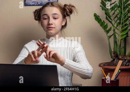 teenage ragazza sordomita bambino scuola ragazza imparante in linea classe sul computer portatile che comunica con l'insegnante tramite videoconferenza con lingua dei segni s Foto Stock