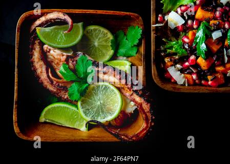 Tentacoli di calamari fritti con lime e melogrenate laterali e dolci insalata di patate Foto Stock