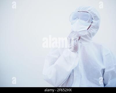 Ritratto di sicuro medico o scienziato asiatico maschile in PPE suite uniforme profondo pensiero creativo persona mano sul mento con spazio di copia per testo o desig Foto Stock