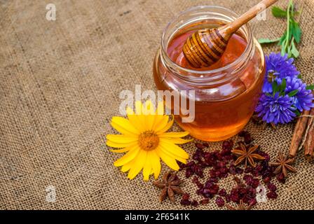 Miele in vaso con cucchiaio di miele su fondo di legno d'annata Foto Stock