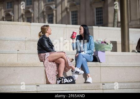 Birmingham, Regno Unito. 30 Marzo 2021. Gli impiegati si rilassano al sole nella recentemente sviluppata Chamberlain Square nel centro di Birmingham. Credit: Peter Lopeman/Alamy Live News Foto Stock