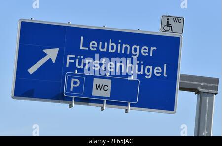 30 marzo 2021, Turingia, Sömmerda: Un cartello autostradale indica la strada per la stazione di servizio Leubinger Fürstenhügel sull'autostrada A71. È uno dei progetti che fanno parte dell'International Building Exhibition (IBA) in Turingia. In futuro, un sentiero porterà dall'area di servizio a un tumulo di sepoltura di 4,000 anni dall'età del bronzo. Foto: Martin Schutt/dpa-Zentralbild/dpa Foto Stock