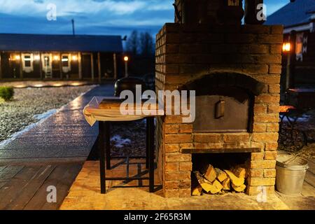 sedie nel gazebo. accogliente terrazza per rilassarsi sotto un baldacchino nel cortile. bella illuminazione del gazebo in serata Foto Stock