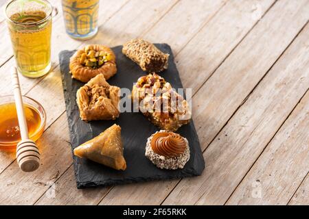 Assortimento di baklava dessert Ramadan e miele su tavola di legno Foto Stock