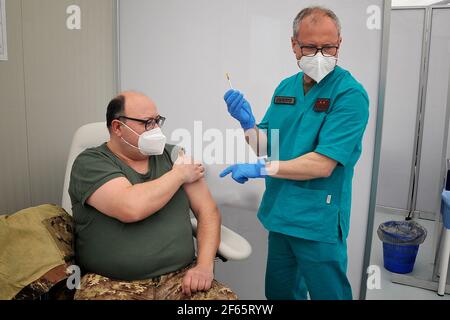 Caserta, Italia, 30 marzo 2021. Il personale medico militare della caserma della Brigata Garibaldi di Caserta "Ferrari Orsi" si sta preparando ad iniettare una dose di vaccino AstraZeneca ad un soldato. Questo centro di vaccinazione all'interno delle caserme consentirà la somministrazione di oltre 1000 vaccini al giorno. Credit: Vincenzo Izzo / Alamy Live News Foto Stock