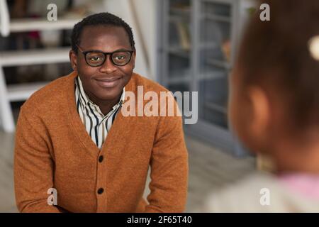 Ritratto di felice padre afroamericano che viene a casa dal lavoro e incontro figlio, copia spazio Foto Stock