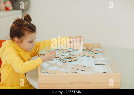 Bambina che gioca con il giocattolo a forma di sabbia. Formazione in età precoce. Concetto di psicologia cognitiva dei bambini piccoli Foto Stock