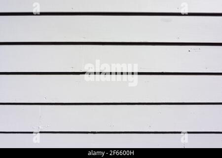 Legno pulito e ordinato che sida all'esterno di un capannone nella luce del mattino. Foto Stock