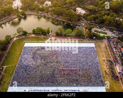 Barishal, Bangladesh. 30 Marzo 2021. Le persone di Barisal, una città del Bangladesh, hanno fatto il più grande logo umano-made in più di 60,000 metri quadrati di area campo per celebrare il 100 ° anno di nascita del Padre della nazione, 'Bangabandhu, Sheikh Mujibur Rahman il 30 marzo 2021. Totale 10,050 cartelloni in totale 120 linee, ciascuna delle quali è composta da 84-85 cartelloni, sono utilizzati per realizzare il logo umano più lungo e più grande. Credit: ZUMA Press, Inc./Alamy Live News Foto Stock