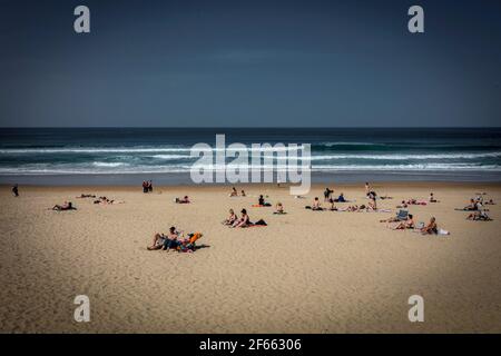 Bagnanti sulla spiaggia. Spiaggia di Zurriola sulla città basca di San Sebastian, Donostia, nel nord della Spagna. Foto Stock