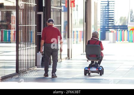 Torrevieja, Spagna, 23.03.2021 anni, coppia senior con una sedia a rotelle nel centro commerciale Foto Stock