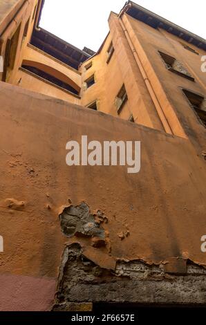 Il muro decadente, il gesso arancione che si stacca, di un vecchio edificio a Vieux Lyon, Francia Foto Stock