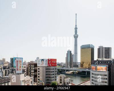 Tokyo, Giappone - edifici e il fiume Sumida sullo sfondo del Tokyo Skytree, la torre di trasmissione più alta del mondo. Foto Stock