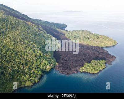 Un vecchio flusso di lava ha fatto la sua strada verso il mare su banda API, un vulcano attivo nelle Isole banda dell'Indonesia. Questo fa parte dell'anello del fuoco. Foto Stock