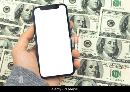 Mockup smartphone in mano uomo su uno sfondo di dollari, modello di business concetto Foto Stock